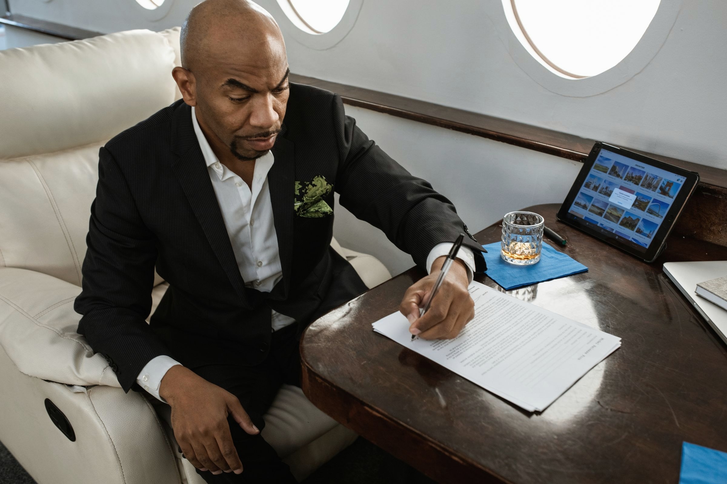White flowers on a walnut table inside a private jet cabin